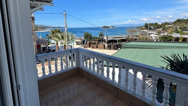 A balcony with a view of the sea, a tiled floor, and a white railing. - Villa Bushi (Ksamil)