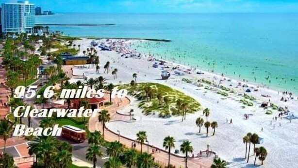 A beach scene with a clear view of the ocean and a road leading to a hotel. - LKB4705AW 4 Bedroom villa in Lake Berkley 4 Home (Kissimmee)