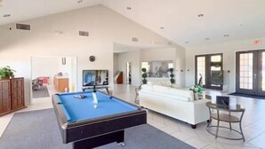 A spacious living area with a pool table, a sofa, and a television. - HG423SP 4 Bedroom villa in High grove 4 Home (Clermont)