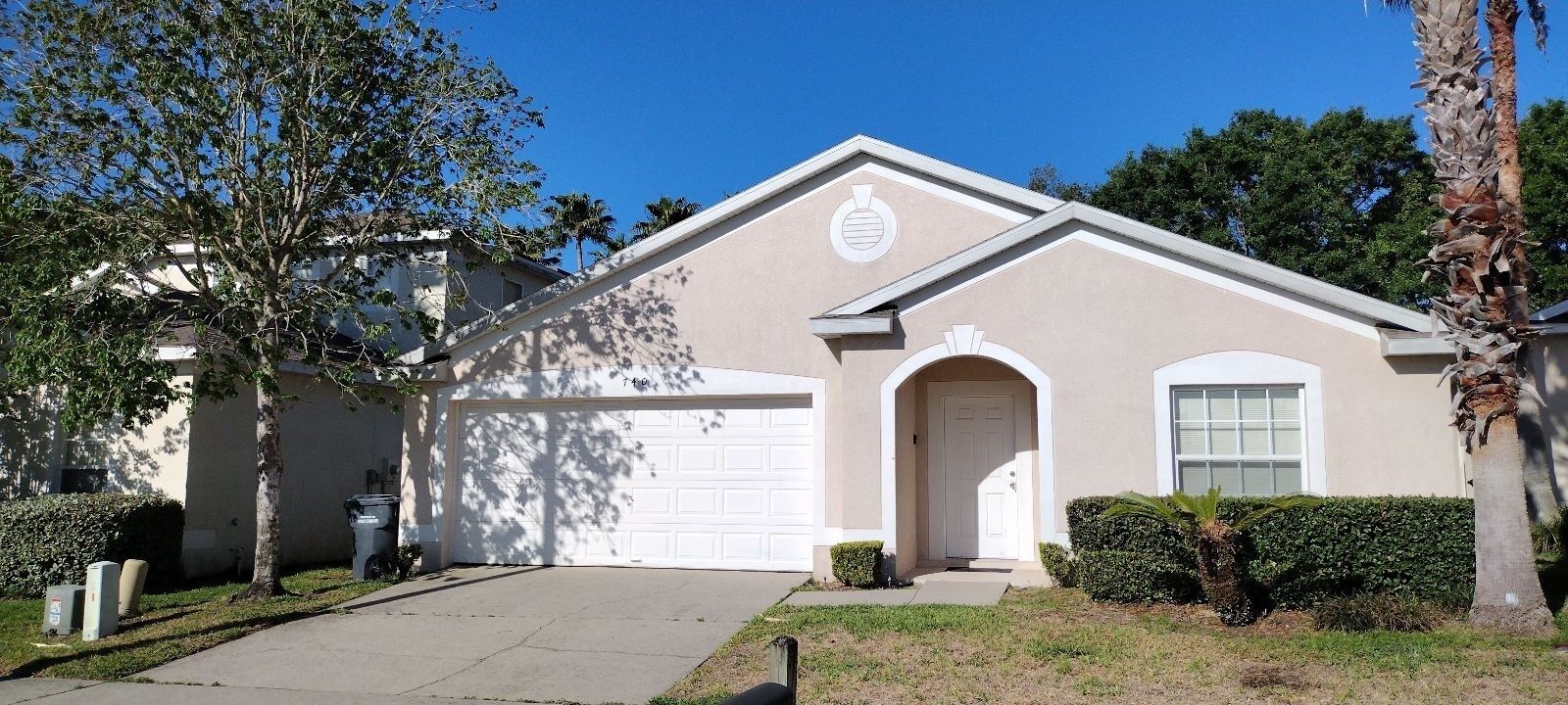 A single-story house with a garage, a front door, and a small front yard.
