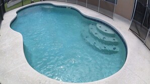A swimming pool with a curved edge and a tiled border. - BT652RB 4 Bedroom Villa in Bella Toscana 4 Home (Davenport)