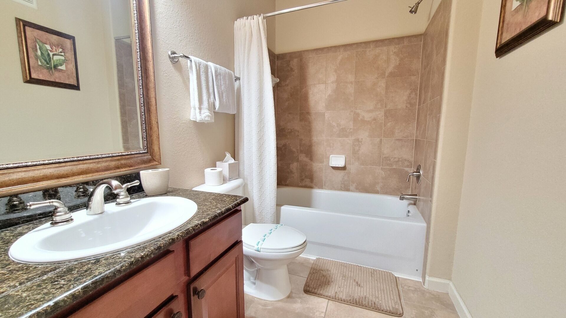 Une salle de bain équipée d’un lavabo, d’un miroir, de toilettes et d’une baignoire.