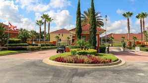 A well-maintained hotel entrance with a paved driveway, palm trees, and a flag. - Sol1520sc 6 Bed Solana Holiday Villa 6 Bedroom Home (Davenport)