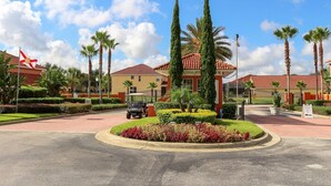 A well-maintained hotel entrance with a paved driveway, palm trees, and a golf cart. - Sol826sc 4bed Solana Private Pool Home 4 Bedroom Home (Davenport)