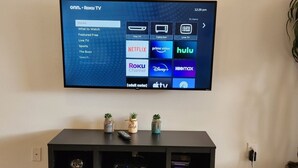 A flat-screen TV mounted on a wall displaying a streaming service interface with various options like Netflix, Hulu, and Disney+. - Sol826sc 4bed Solana Private Pool Home 4 Bedroom Home (Davenport)