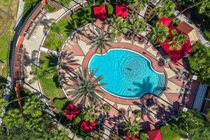 A circular pool surrounded by palm trees and red umbrellas, with a paved walkway and a covered seating area. - Sol826sc 4bed Solana Private Pool Home 4 Bedroom Home (Davenport)