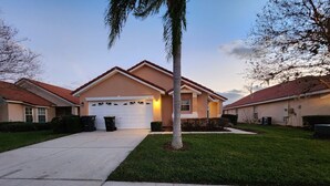 A residential house with a garage, a well-maintained lawn, and a clear sky. - Sol826sc 4bed Solana Private Pool Home 4 Bedroom Home (Davenport)