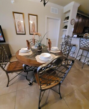 A dining area with a round table, metal chairs, and a small potted plant. - Bp122cp Mediterranean-style Condo 9 Miles To Disney World 3 Bedroom Condo (Davenport)