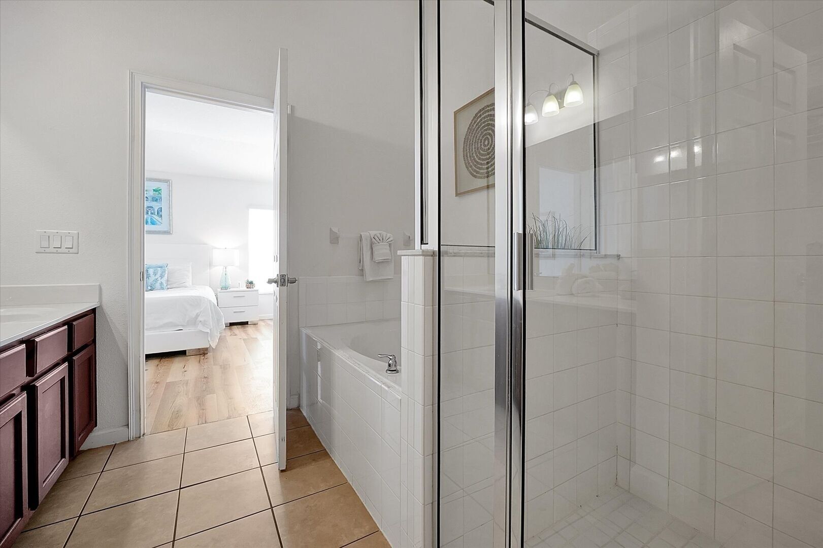 Un baño moderno con cabina de ducha de vidrio, un lavabo blanco y una bañera.