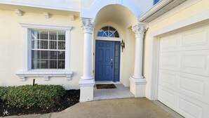 A house with a blue door, white garage door, and a small porch with a doormat. - Cp938od 5 Bed Calabay Parc 5 Bedroom Home (Davenport)