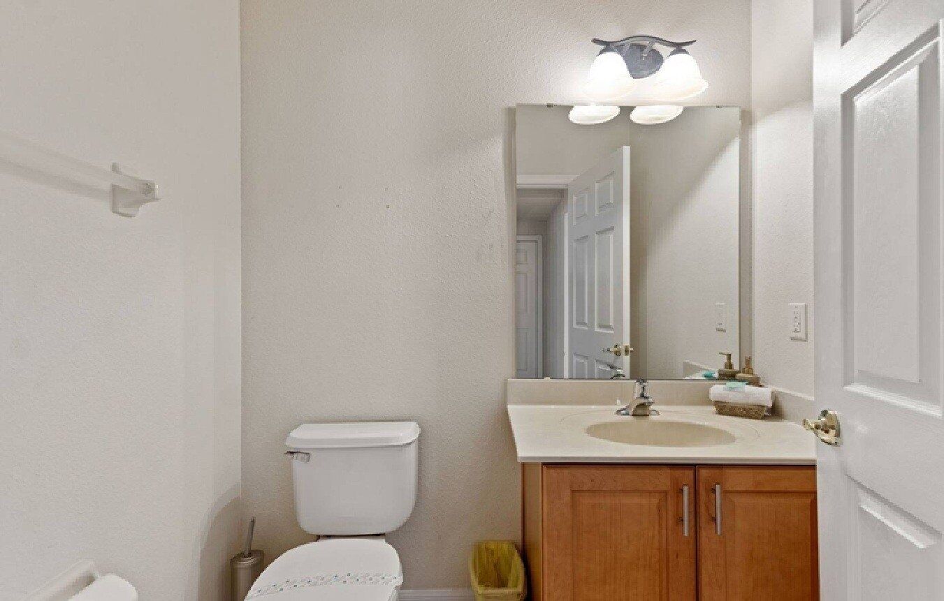 Een kleine badkamer met toilet, wastafel en spiegel.