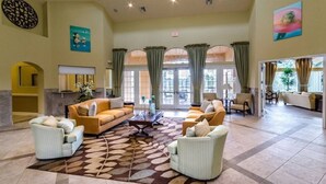 A spacious lobby with a large seating area, a fireplace, and large windows. - Ws192tl Watersong 5 Bed Pool Home 5 Bedroom Home (Davenport)