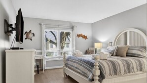 A bedroom with a bed, a desk, a TV, and a window with curtains. - Sea Pines - 867 Ketch Court 2 Bedroom Home (Hilton Head Island)