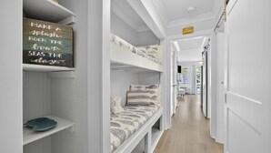 A narrow hallway with bunk beds and a shelf with a motivational sign. - South End - 180 Sea Side Villas 1 Bedroom Condo (Hilton Head Island)
