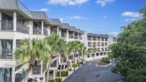 A row of multi-story hotel buildings with balconies, arranged in a linear street view. - South End - 180 Sea Side Villas 1 Bedroom Condo (Hilton Head Island)