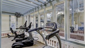 A gym with exercise equipment, large windows, and a view of the outside. - Sandy Beach Escape - Monthly Rates Until 2/28/26! 2 Bedroom Condo (Hilton Head Island)