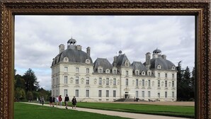 Château de Cheverny, ett historiskt slott med en symmetrisk fasad, stora fönster och flera skorstenar.