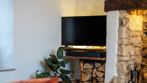 Un soggiorno accogliente con camino, televisore e un'area salotto confortevole.
