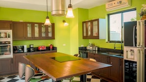 A kitchen with a wooden table, green walls, and a checkered floor.