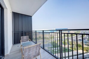 A balcony with a view of a highway and buildings. - Bloomfields 1BR in Water's Edge 8- Yas (Abu Dhabi)