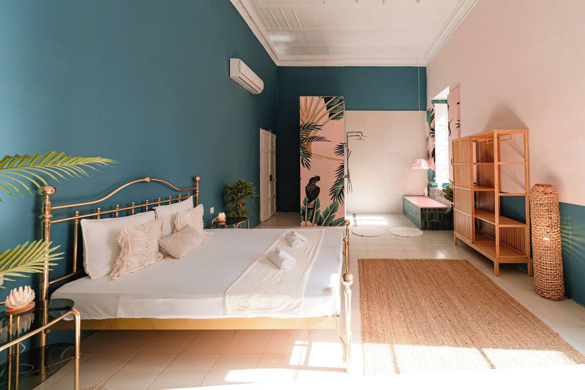 A bedroom with a bed, bedside table, and a wooden wardrobe.