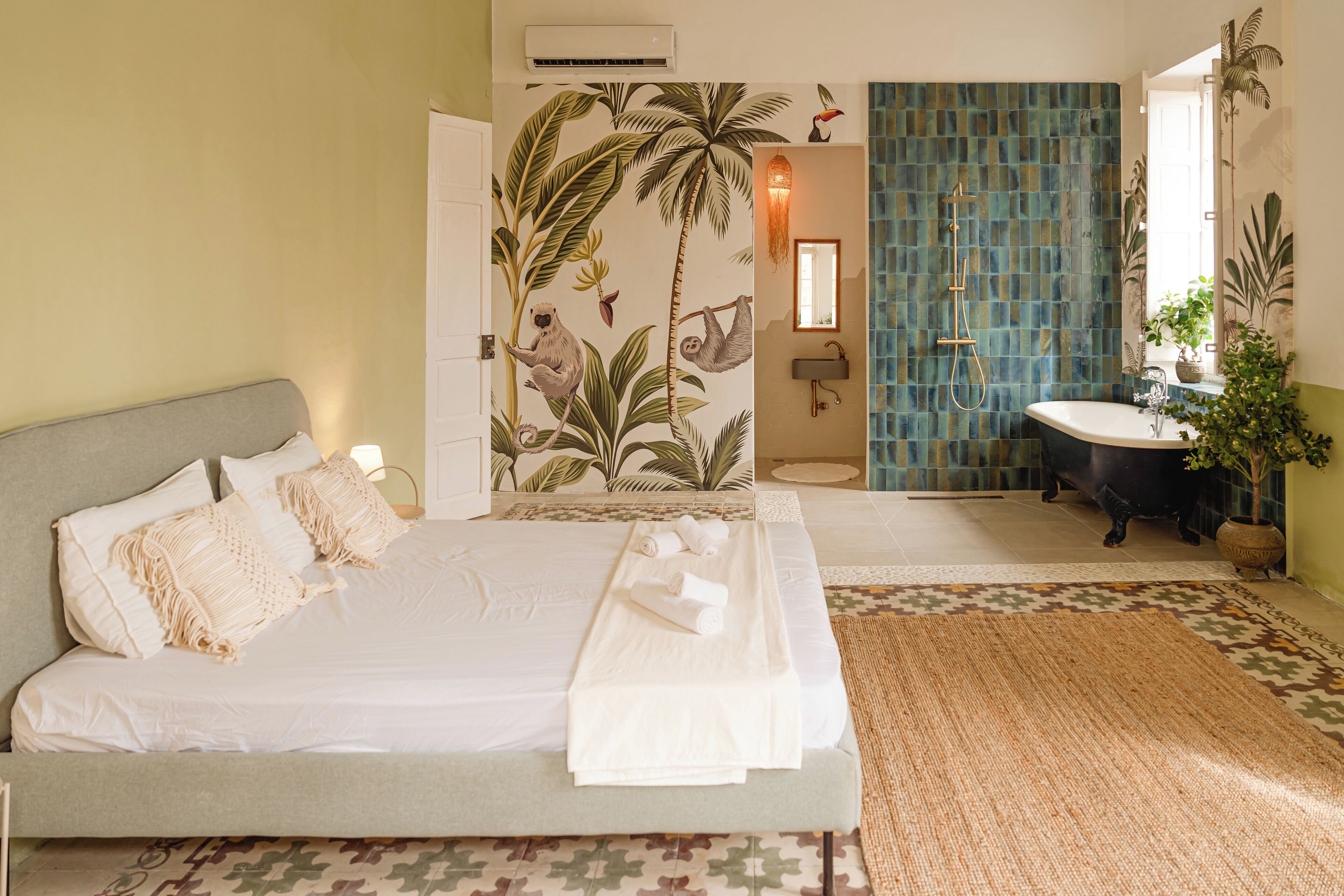 Un dormitorio con cama, un baño con bañera y ducha.