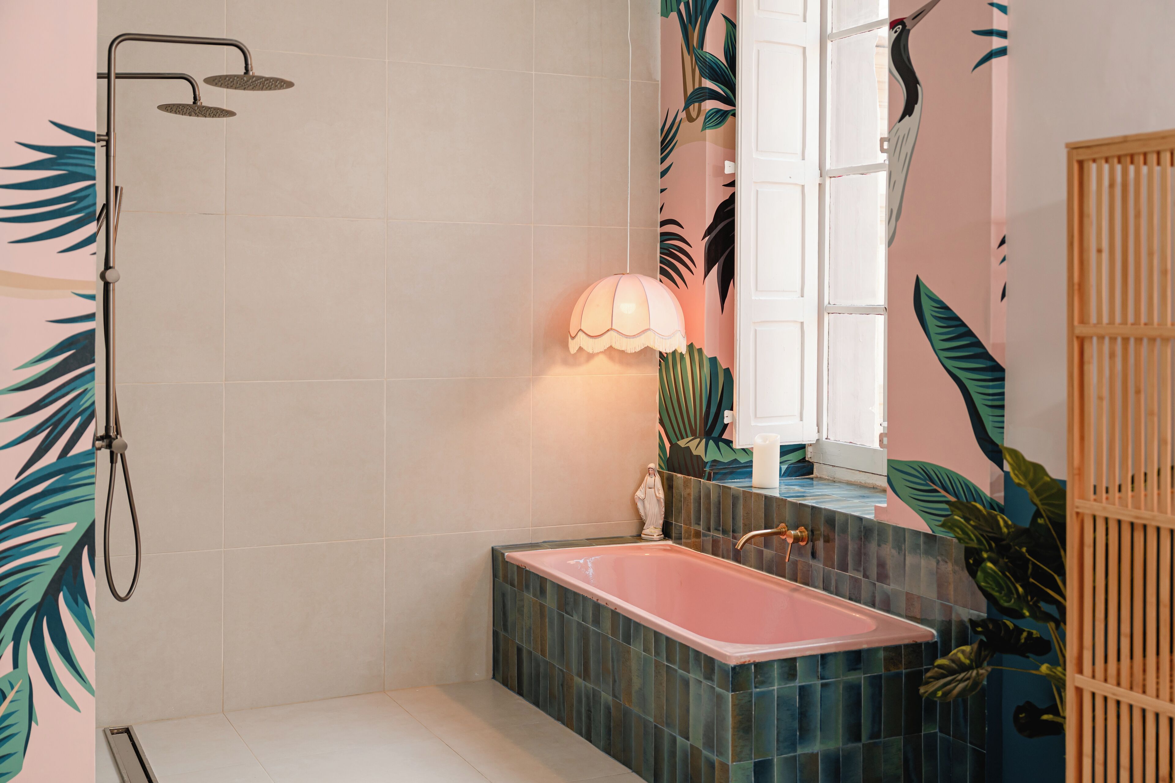 Un baño con bañera, ducha y ventana con una planta afuera.