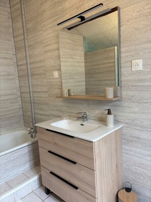 A bathroom with a white sink, wooden vanity, a mirror, and a shower. - Comfortable country gîte in the Pays de Tronçais fishing/walking and cycling (Valigny)