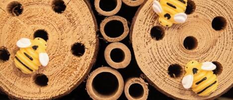 A collection of wooden dowels with holes, some featuring yellow bee decorations.