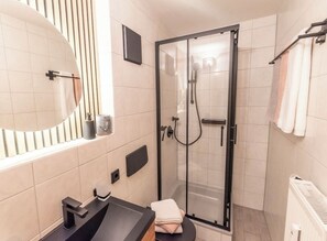 Een haardroger, handdoeken, zeep, toiletpapier