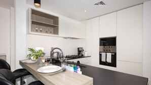 Una cocina moderna con encimera de madera, electrodomésticos de acero inoxidable y horno empotrado.