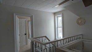 A modern interior with a staircase, a white door, and a clock on the wall.