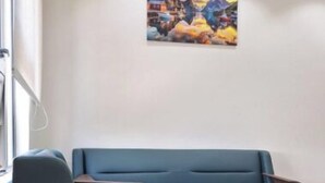 A modern living room with a blue sofa and a brown armchair. - Amazing 4-bedroom villa in Grand Baie perfect for your getaway (Grand Baie)