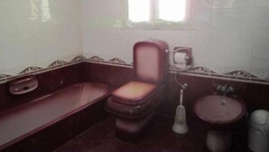 Et badeværelse med toilet, bidet og håndvask.