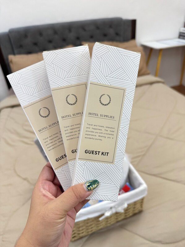 A hand holding three guest kits with text and a geometric pattern.