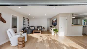 Una sala de estar moderna con un sofá, un sillón, una mesa de centro y un televisor.