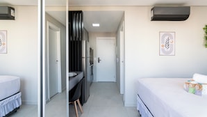 Een moderne hotelkamer met een bed, bureau en garderobe.