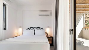 A bedroom with a bed, bedside tables, an air conditioning unit, and a view of the outdoors. - Boutique Villa Ciel Tinos (Tinos)