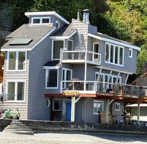 Un immeuble à plusieurs étages doté d’un balcon, d’un garage et d’une allée bien visible.