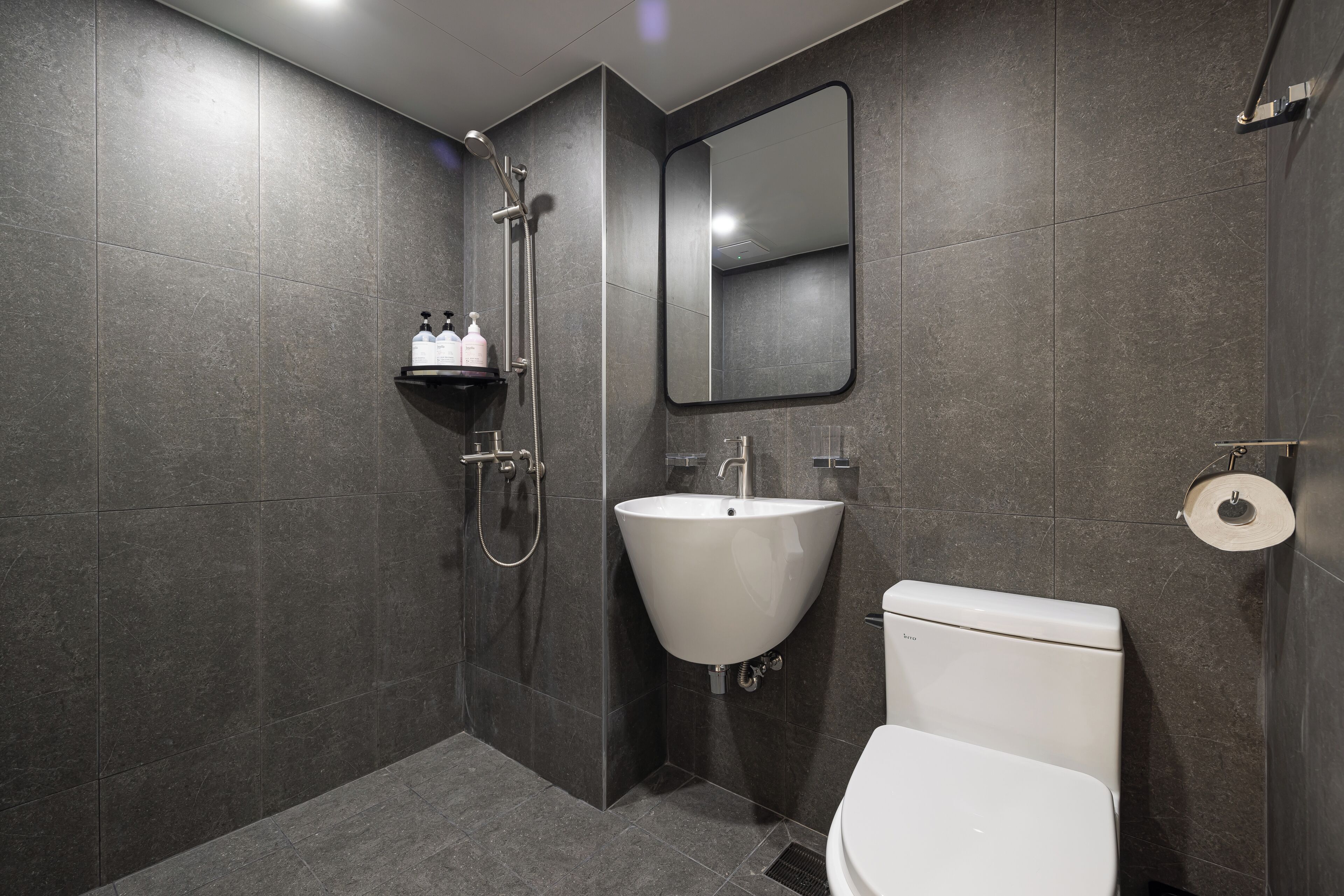Ein modernes Badezimmer mit Toilette, Waschbecken und Dusche.