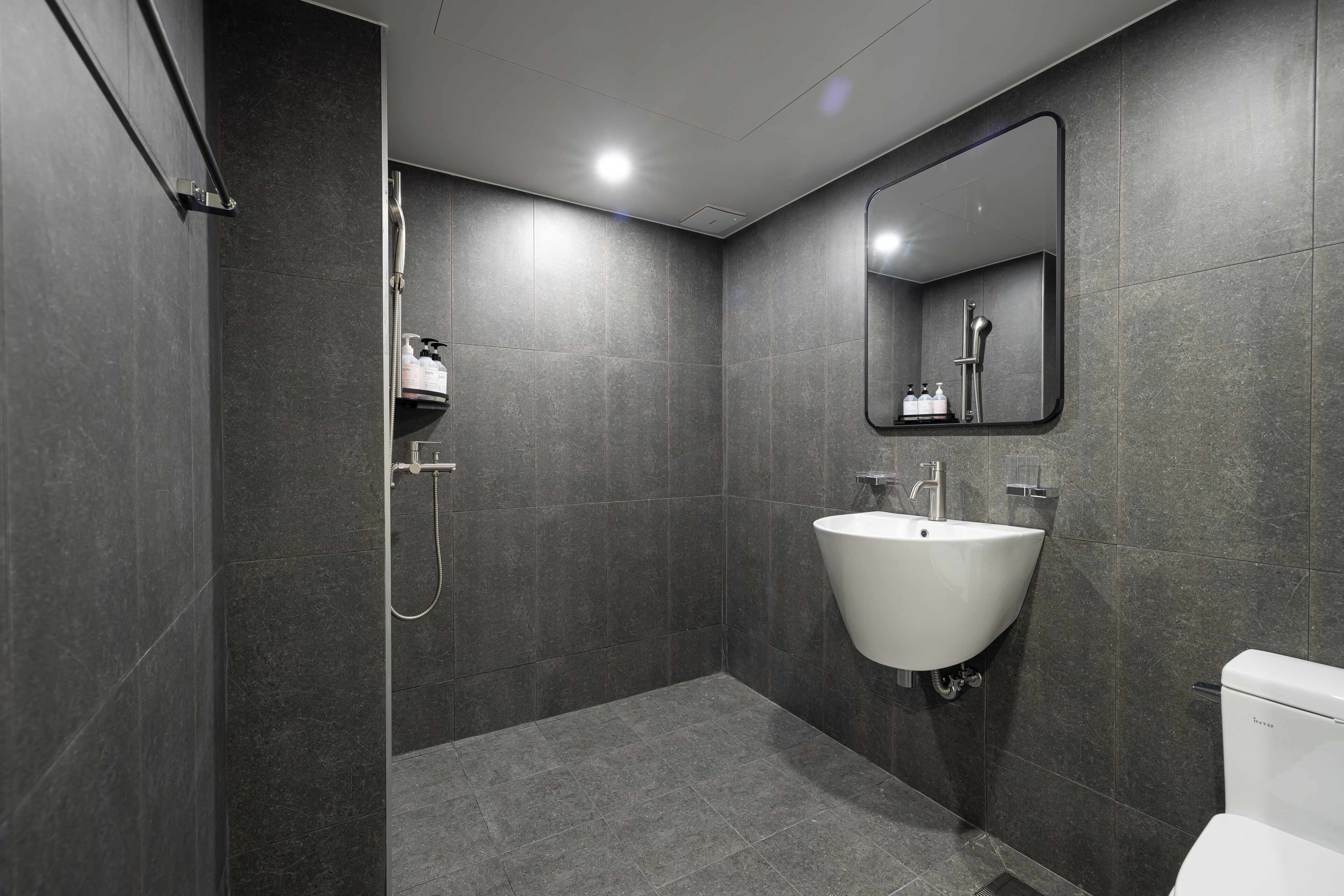 Un bagno moderno con doccia, lavandino e WC.