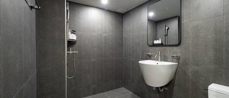 Un bagno moderno con doccia, lavandino e WC.