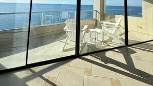 A balcony with a view of the ocean, large windows, and outdoor seating. - Palacio Del Mar 505- Rocky Point Oceanfront 4 Bedroom/4 Bath (Puerto Peñasco)