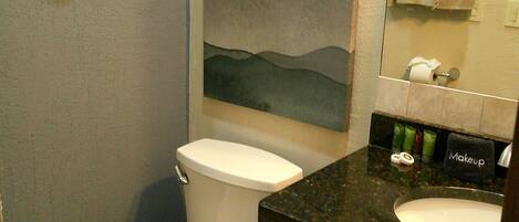 A bathroom with a toilet, sink, and a towel rack.