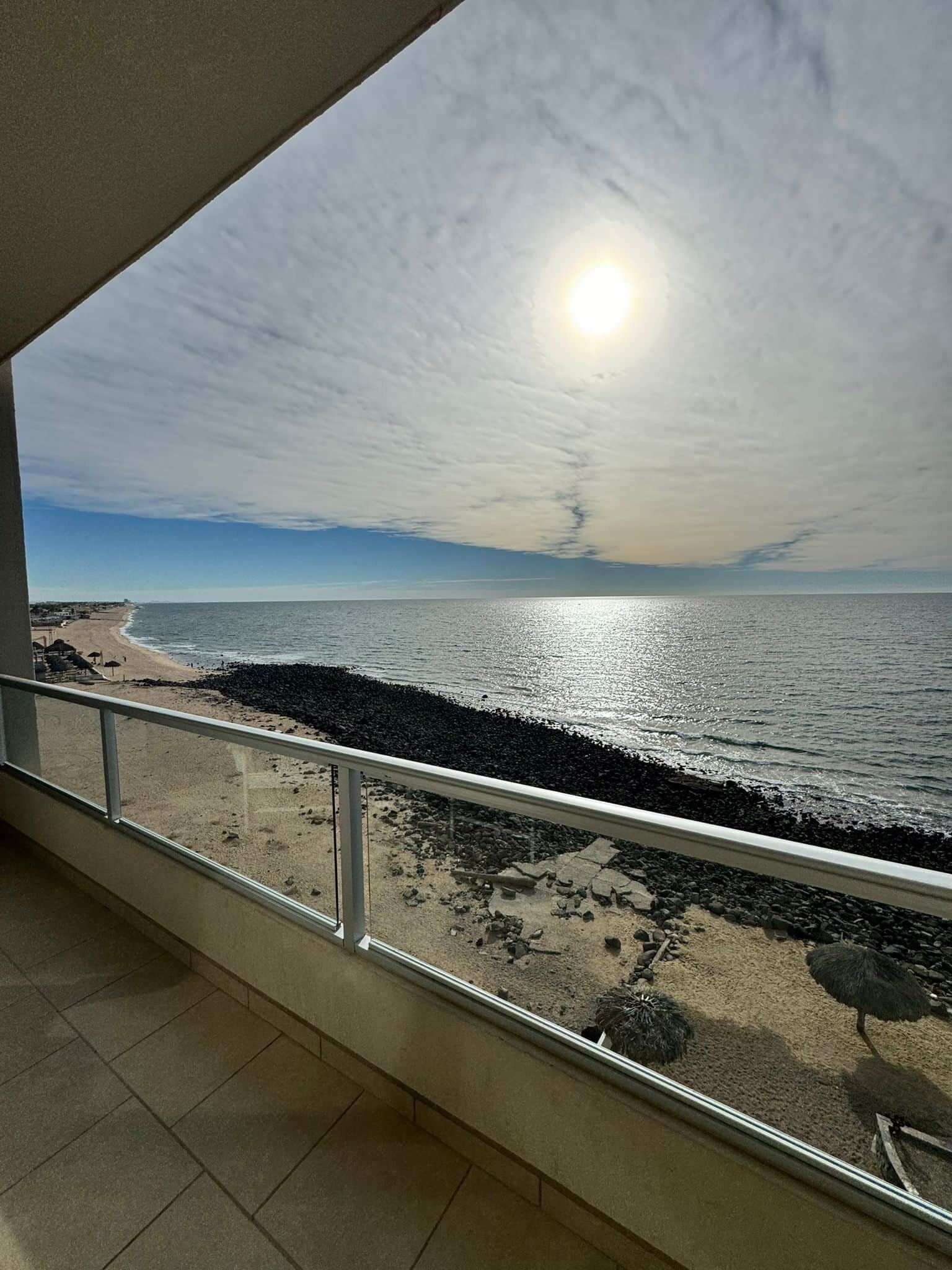 Un balcón con vista a la playa y el océano.