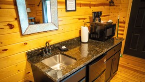 A compact kitchen with a granite countertop, stainless steel sink, and a microwave. - Horseshoe Canyon Ranch (Jasper)