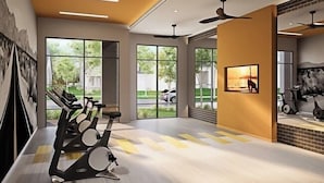 A modern gym with exercise equipment, large windows, and a mural. - Landing Furnished Apartments West Huntsville (Huntsville)