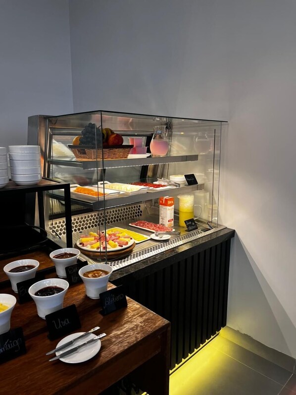 Un bufé de desayuno con diversas opciones de comida y acompañamientos.