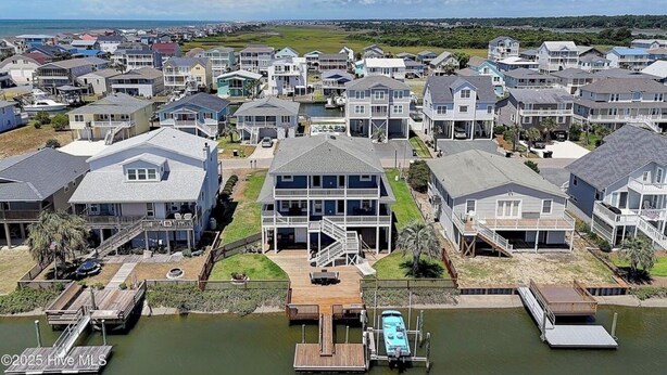A coastal residential area with houses featuring balconies and waterfront access. - 5 BR Canal front Retreat w/ Dock, EV Charger & 3-Min Walk to Holden Beach (Holden Beach)