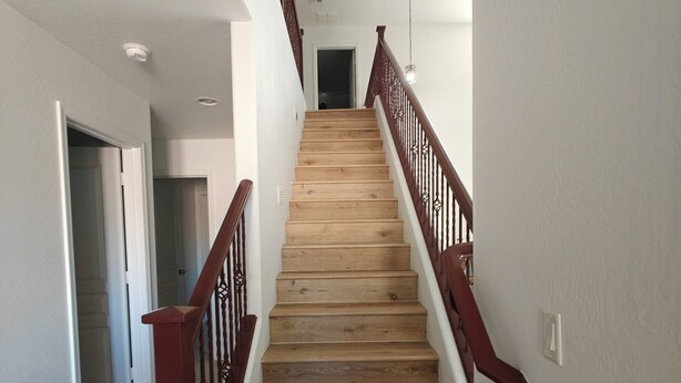 A wooden staircase with a handrail, leading to an upper floor. - La Rosa Phoenix (Phoenix)
